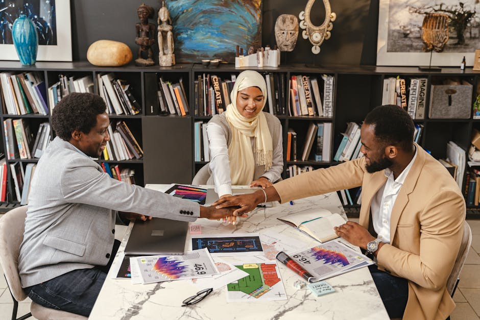 Three professionals in an office setting engage in team collaboration, fostering innovation and cooperation