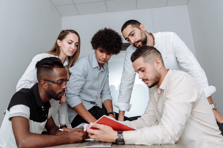 A multicultural team engaged in a collaborative office meeting, discussing ideas around a table